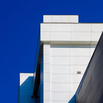 This is an artistic representation showcasing the geometric structure of a modern building beneath a clear blue sky