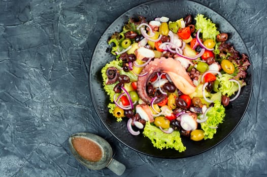 Appetizing salad of octopus, potatoes, olives and greens. Copy space.