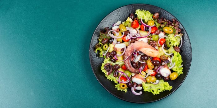 Appetizing salad of octopus, potatoes, olives and greens. Copy space.