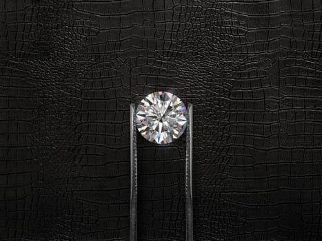 Cut Beautiful diamond held by tweezers, on a black leather background