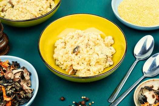 Yellow millet grain porridge with mushrooms. Vegan healthy food. Copy space.