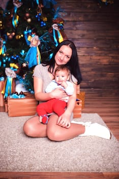A touching and loving moment beautifully captured of a mother and her child standing by a decorated Christmas tree