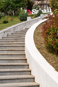 A stone staircase, enveloped by verdant foliage, ascends to a prominent I Love Sabail sign in Sabail Park, Baku, Azerbaijan