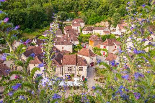 The old village of Saint-Cirq-Lapopie seen from the heights and the flowers, Occitanie region, in the southwest of France