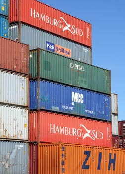 HAMBURG, GERMANY - JUNE 1, 2020: Stacked shipping containers of CAPITAL, MCC, P&O Nedlloyd, HAMBURG SUED and ZIH Zhengzhou International Hub at the Port of Hamburg and blue sky