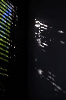 Shadow of the rays falling on the wall through the louvers.