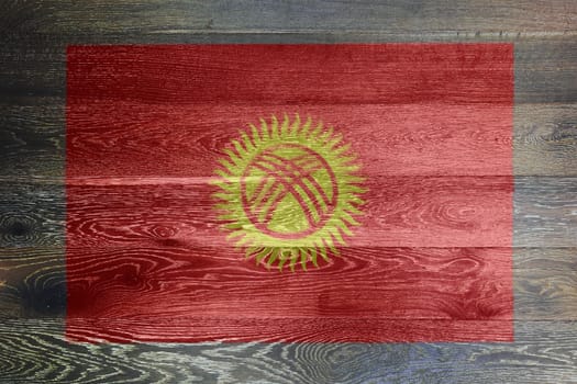 A Kyrgyzstan flag on rustic old wood surface background