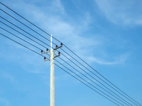 Reinforced concrete pillar with high-voltage wires against a clear blue sky. Transmission of electricity by wires over long distances. Electricity power lines against a clear sky.