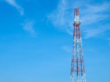 A telecommunications tower with various forms of antennas installed on its body, High antenna tower pillar of cellular communication on the blue sky background.