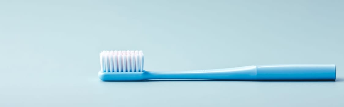 Toothbrush with blue handle on light blue background, concept of dental hygiene, AI Generated