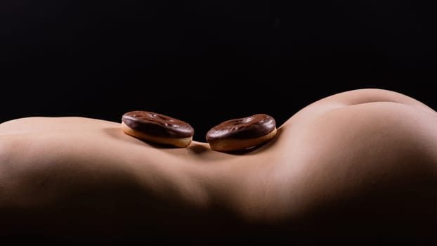 Plus size seductive model female, fashionable blonde in a black bodysuit with donut
