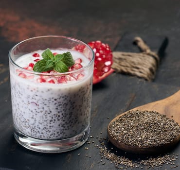 Glass of chia seeds and yogurt with pomegranate on table