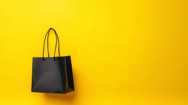 A single black shopping bag on a bright yellow background, ideal for retail design with copy space. Black Friday sale concept with empty place for text.
