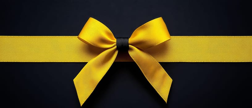 Elegant yellow ribbon with a bow on a dark surface, perfect for decoration and celebration themes. Black Friday sale concept with empty place for text.