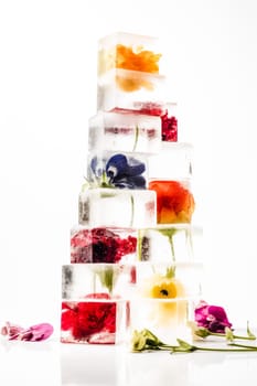 high stack of different ice cubes with flowers inside on a white background. Generative AI
