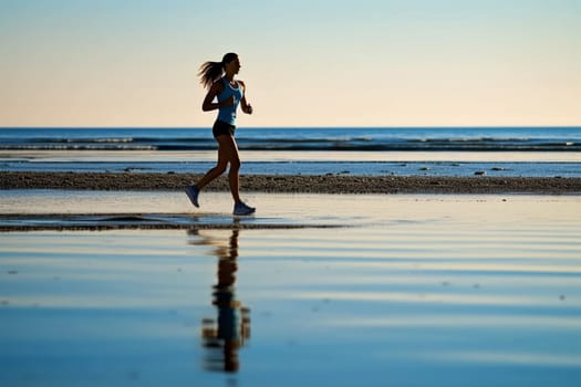 athletic beautiful young woman runs along the beach, goes in for sports in sportswear.