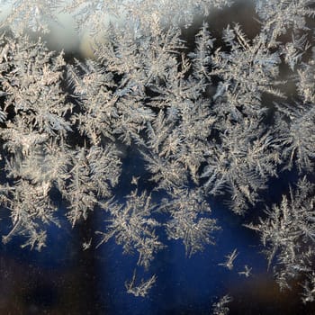 Snowflakes frost rime macro on window glass pane. Colorful ice on the window surface, natural background texture