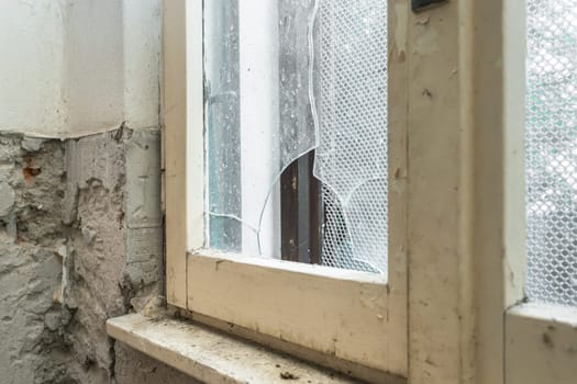 Old abandoned building. Glass of old window broken. Abandoned house. Peeling walls of the room.