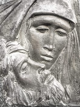Jesus and Mary. Bronze bas-relief of Mother Mary holding her son Jesus.