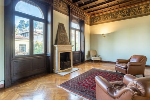 Interior of an ancient luxury house. Decorated wooden ceiling. Elegant fireplace. Living room.