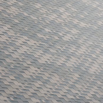 Flexible shingles of bitumen roofing surface. Background mosaic texture of flat roof tiles with bituminous coating