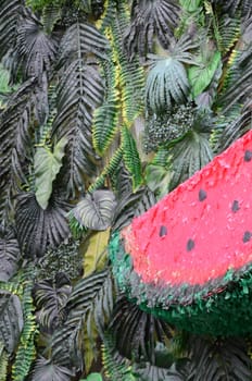 Tropical pattern with jungle leaves and watermelon fruit floral background. Plastic watermelon slice with palm leaf