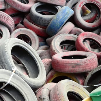 A picture of many old used tires left on a waste dump. The picture of an ecological problem and disaster