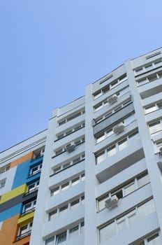 New multy storey residential building and blue sky. Residential houses with many windows and air condition fans