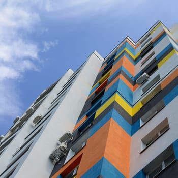 New multy storey residential building and blue sky. Residential houses with many windows and air condition fans