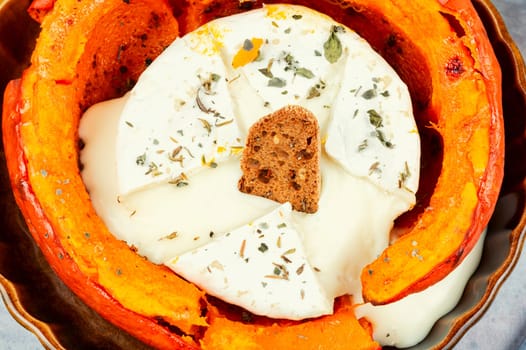 Pumpkin baked with camembert cheese in a pumpkin. Healthy eating.