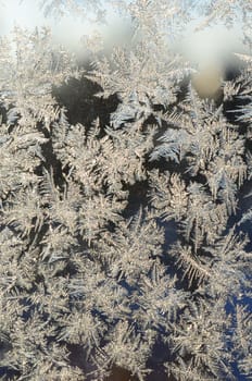 Snowflakes frost rime macro on window glass pane. Colorful ice on the window surface, natural background texture