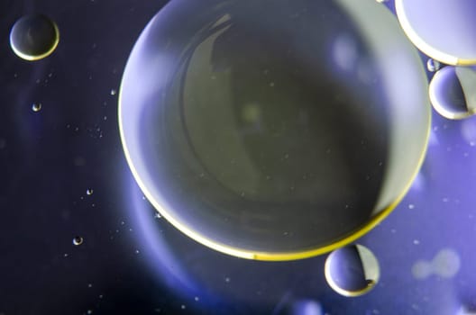 Extreme close up of oil bubbles on water surface