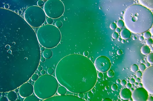 Close up of oil bubbles on water surface. Multicolored background