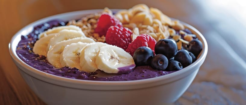 A vibrant acai bowl topped with fresh blueberries, sliced strawberries, banana, and granola, served in a clear bowl