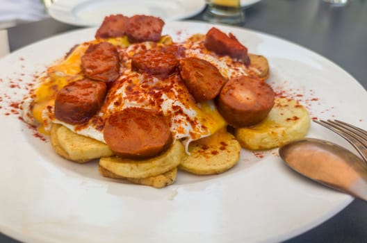 Morcilla patatera served over fried eggs and potatoes. Selctive focus
