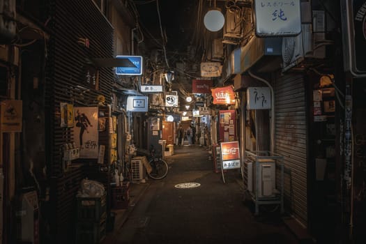 Narrow alley in tokyo at night showing restaurants and bars