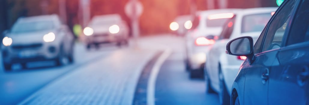 Cars standing in the row on the urban asphalt road. City life concept.