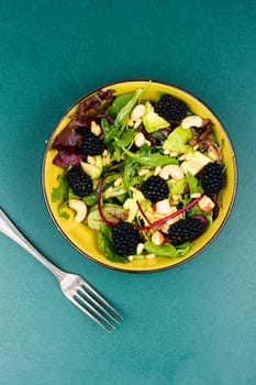 Summer food, salad with fresh blackberries garnished with fresh herbs. Healthy food. Top view.
