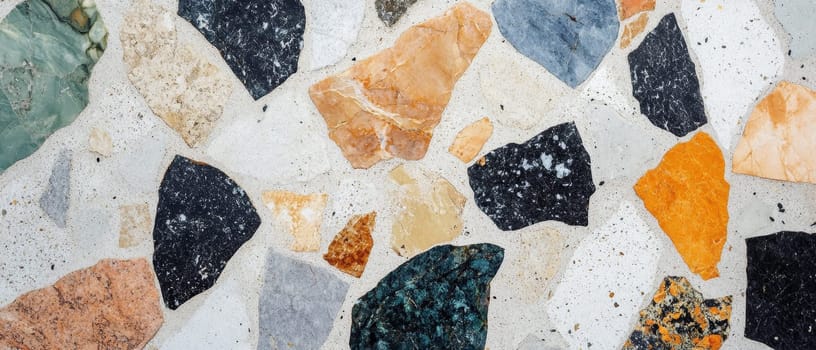 Close up of vibrant terrazzo texture with multicolored stone fragments embedded in concrete, creating a modern and artistic surface pattern.
