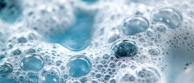 Extreme close up of delicate soap bubbles with various sizes, showcasing iridescent surfaces and reflections in shades of blue and white.