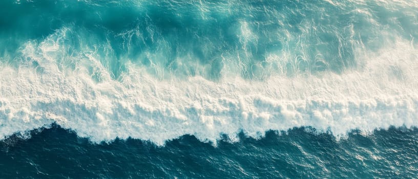 Stunning aerial perspective of turquoise ocean waves crashing with white foam, showcasing the power and beauty of nature.