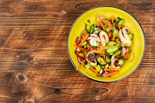 Thai spicy squid or calamari salad in plate. Space for text.