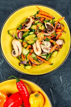 Thai spicy squid or calamari salad in plate. Space for text.
