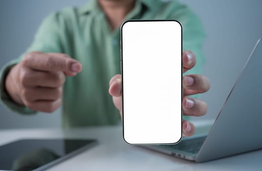 Businessman hand holding smartphone with white empty screen in hand, Smartphone mockup for online shopping, Booking and banking concept, Online education or online business with copy space.