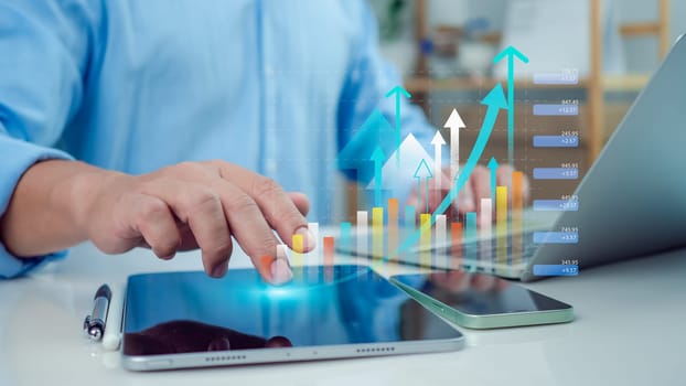 Businessman use tablet showing a growing virtual hologram of analytics dashboard with charts, Stock market, Business growth, Progress or success concept, Invest in trading, Finance, Sales, Marketing.