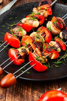 Succulent grilled octopus tentacles with bell pepper on a concrete kitchen table.