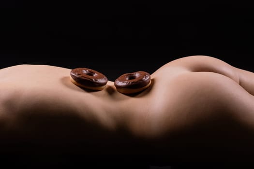 Plus size seductive model female, fashionable blonde in a black bodysuit with donut