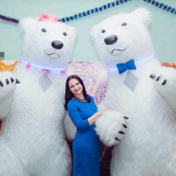 A joyful celebration with a woman and giant polar bear mascots dressed in festive and vibrant attire