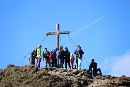Mountain hikers at the summit cross of the Monte Cavallo in the hiking paradise and holiday region of South Tyrol / Alto Adige above Vipiteno