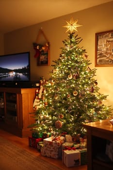 The living room is warmly lit with a beautifully decorated Christmas tree, ornaments sparkling, and presents placed beneath it.